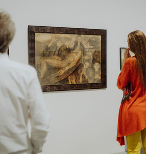 Grupa ludzi zwiedzaja wystawę Aleksandry Waliczewskiej.