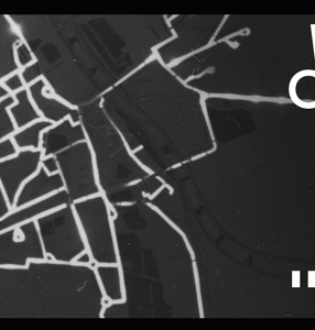 Na czarnym tle przedstawione są białe drogi tworzące plan miasta. W prawym górnym rogu znajduje się logo festiwalu Warszawa w Budowie. 