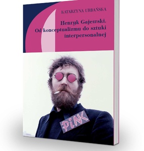 Okładka książki z tytułem na różowym tle i mężczyzną w różowych okularach, papierorem i napisem „pink\