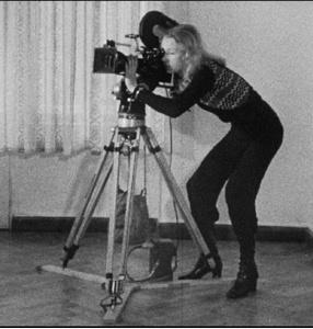 Zdjęcie. Czarno-białe. Kobieta obsługuje dużą kamerę filmową. 