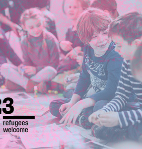 Zdjęcie. Grupa dzieci na warsztatach. Napis: Refugees welcome/ 
