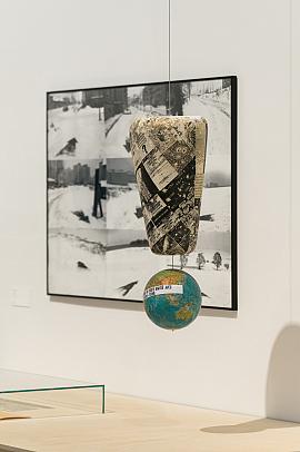 Zdjęcie pracy na wystawie, zawieszonego w przestrzeni wykrzyknika. którego kropka jest globusem, modelem Ziemi