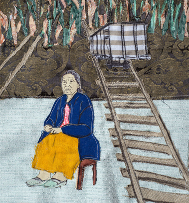 Obraz jest uszyty z różnych tkanin. Przedstawia kobietę ubraną w żółtą spódnicę i niebieską kurtkę, która siedzi na stołku, obok niej po torach jedzie wagon w stronę lasu.