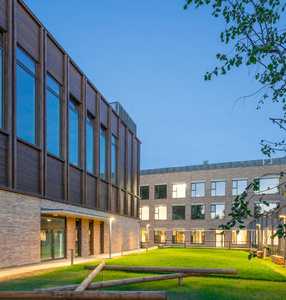(zdjęcie przedstawia rozświetlony budynek szkoły, a przed nim zielony trawnik)