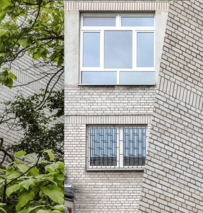 Kolaż zdjęć składających się z różnych ujęć budynku szkoły: zielone liście drzew pokrywają ścianę budynku, kilku skrzydłowe okna, z których jedno jest zakratowane oraz mur pokryty wzorem w drobne cegiełki
