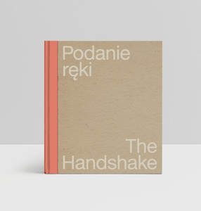 Beżowa okładka z pomarańczowym grzbietem i białym napisem: Podanie ręki i po angielsku: The Handshake