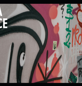 Zdjęcie. Kolorowe graffitii na betonowej ścianie. Na nim napis Walka o ulice. Warszawa w budowie. Festiwal.