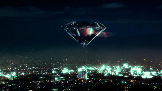 zdjęcie przedstawiające diament wiszący na nocnym niebie ponad miastem