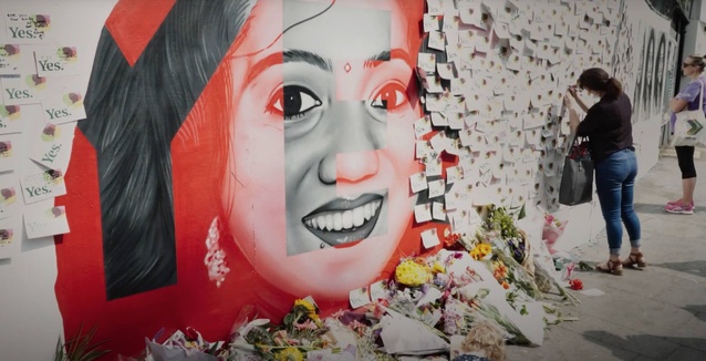 (kadr z filmu przedstawiający kolorowy mural z twarzą roześmianej kobiety)