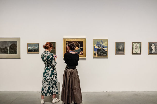 Dwie kobiety stoją przed obrazami Aleksandry Waliszewskiej
